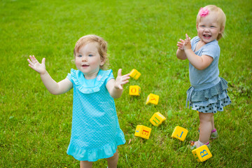 Little girls on nature playing toy