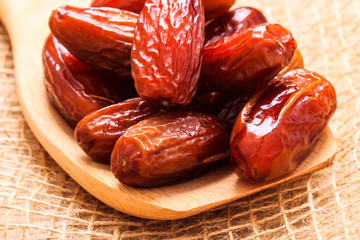 dried dates on wooden spoon cloth background