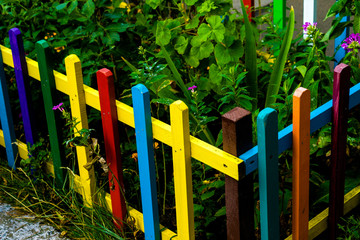 Multi colored rainbow wooden fence in garden background