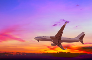 Fototapeta na wymiar Commercial airplane flying at sunset