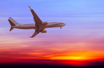 Commercial airplane flying at sunset
