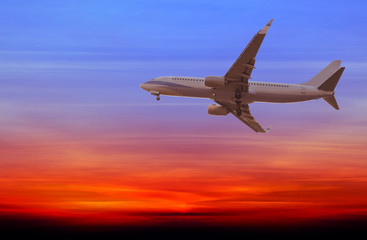 Fototapeta na wymiar Commercial airplane flying at sunset