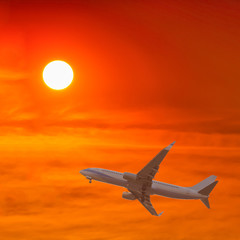 Commercial airplane flying at sunset