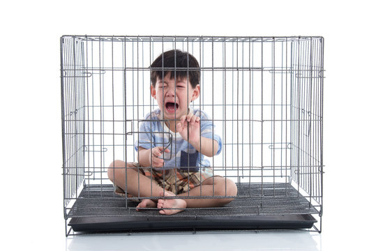 Little asian boy crying in a cage