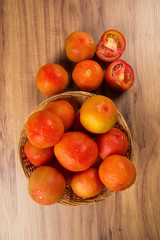 Some tomatoes over a wooden surface on a tomato field as backgro