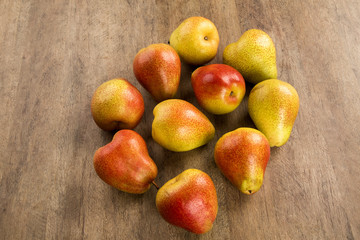 Some pears in a basket over a wooden surface seen from above