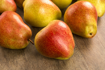 Some pears in a basket over a wooden surface seen from above