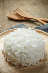 Thai jasmine rice in wooden dish with napery and wooden spoon -