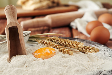 Egg yolk in flour close up on a wooden table in a bakery. Rustic style. Copy space. Free space for text