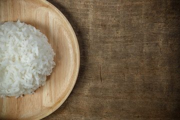 Organic White Rice in wooden dish on wooden table - soft focus