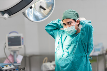 Fototapeta na wymiar Male surgeon tying mask at operating room