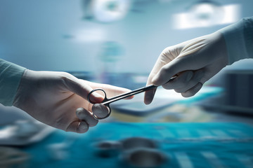 healthcare and medical concept , Close-up of surgeons hands holding surgical scissors and passing...