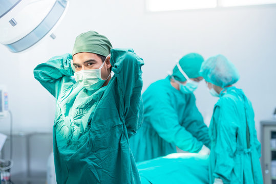 Male Surgeon Tying Mask At Operating Room