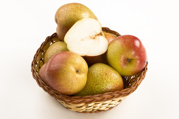 Some pears in a basket over a wooden surface seen from above
