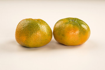 Some tangerines in a basket over a wooden surface