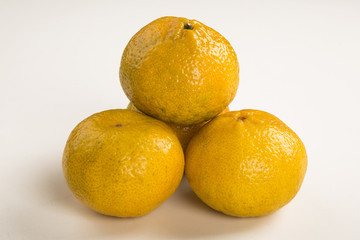 Some tangerines in a basket over a wooden surface