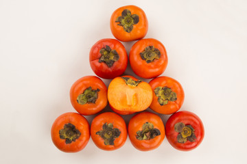 Some khaki fruits over a wooden surface