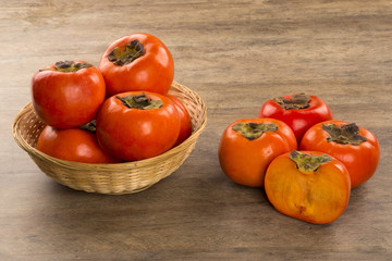 Some khaki fruits over a wooden surface
