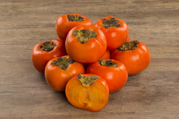 Some khaki fruits over a wooden surface