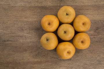 Some asian pears over a wooden surface