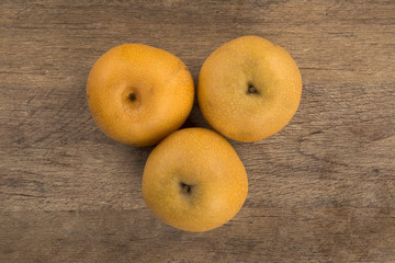 Some asian pears over a wooden surface
