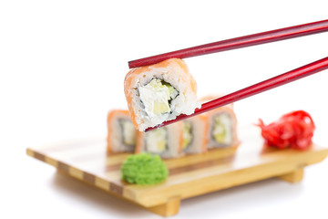 Philadelphia sushi roll in chopsticks isolated on white background