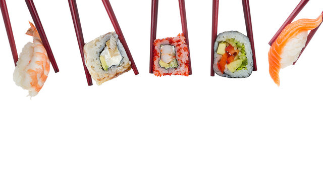Many different sushi and rolls in chopsticks isolated on white background