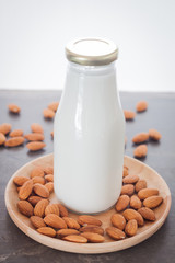 Almond nuts on wooden plate with milk