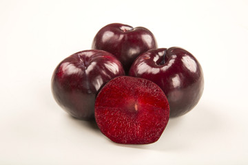 Fresh bright plums in the bowl on board