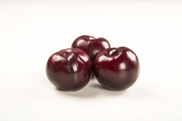 Fresh bright plums in the bowl on board
