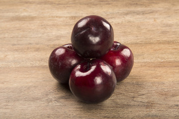 Fresh bright plums in the bowl on board