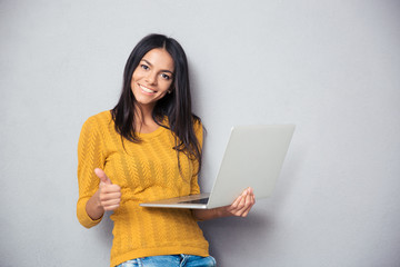 Smiling beautiful woman holding laptop