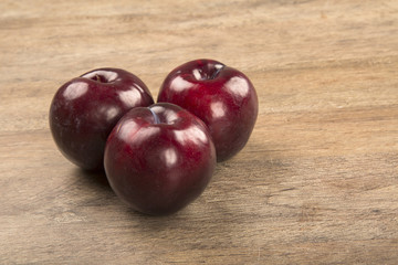 Fresh bright plums in the bowl on board