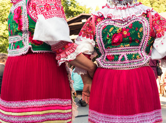 Anonymous senior female friends in folklore costumes