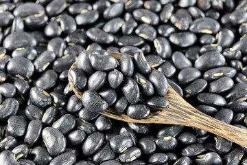 pile black beans and wooden spoon.