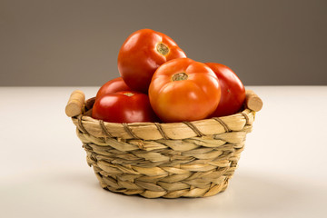 Some tomatoes over a wooden surface on a tomato field as backgro