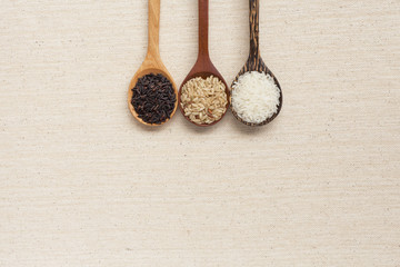 Rice in wooden spoon with space on background