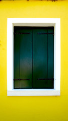green wood paint Window in Burano with bright yellow wall