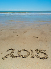 Summer handwritten in the sand of the beach with a lovely heart