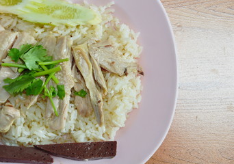 slice boiled chicken topping on rice steamed with chicken soup