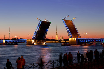 Fototapeta na wymiar Tourists watching the divorce of the Palace bridge in St. Petersburg. White night. Russia