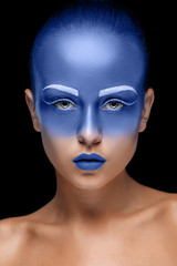 Portrait of a woman who is posing covered with blue paint