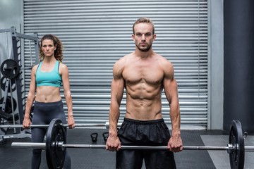 Fototapeta na wymiar Muscular couple lifting weight together