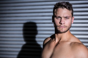 Obraz premium Portrait of serious muscular man looking at camera