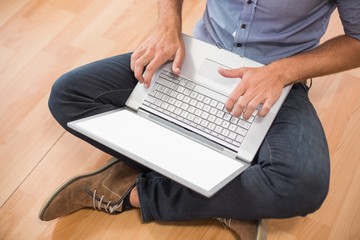 Upward view of young creative businessman working on laptop