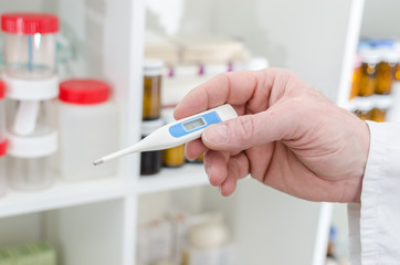 Doctor holding a medical thermometer