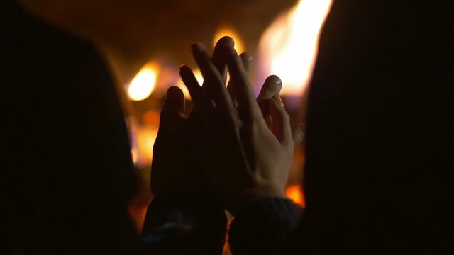 The couple (pair) hold hands by bonfire backghround. Real time
