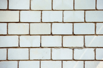 A closeup vertical image of old white textured bricks wall.