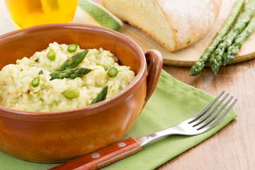 risotto with asparagus in a terracotta bowl over a green napkin