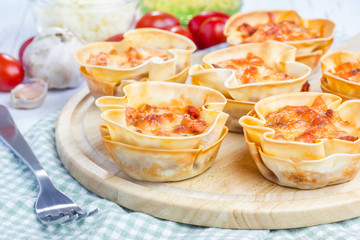 Homemade lasagna cups with minced meat, bolognese sauce topped with cheese
